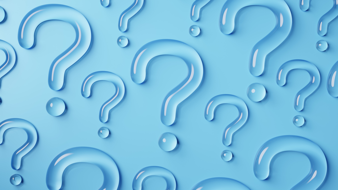 Question marks of various sizes made out of water sitting on top of a blue background.